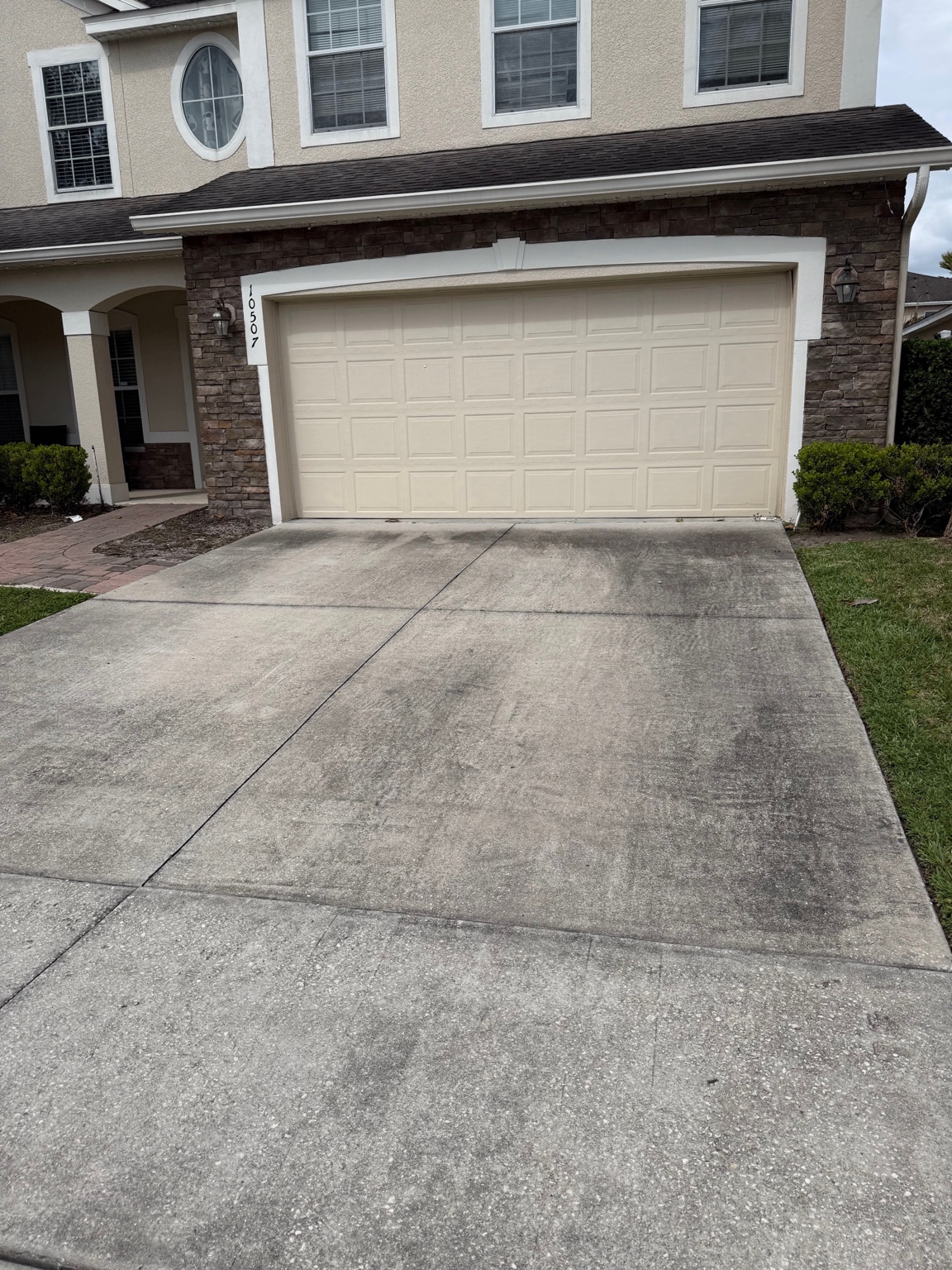 Before: dirty driveway and walkway with organic buildup at a Central Florida home